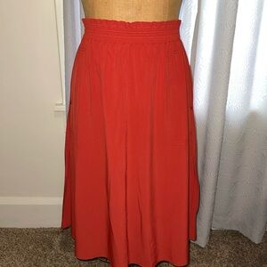 Athlete travel skirt in rust/orange color. Medium